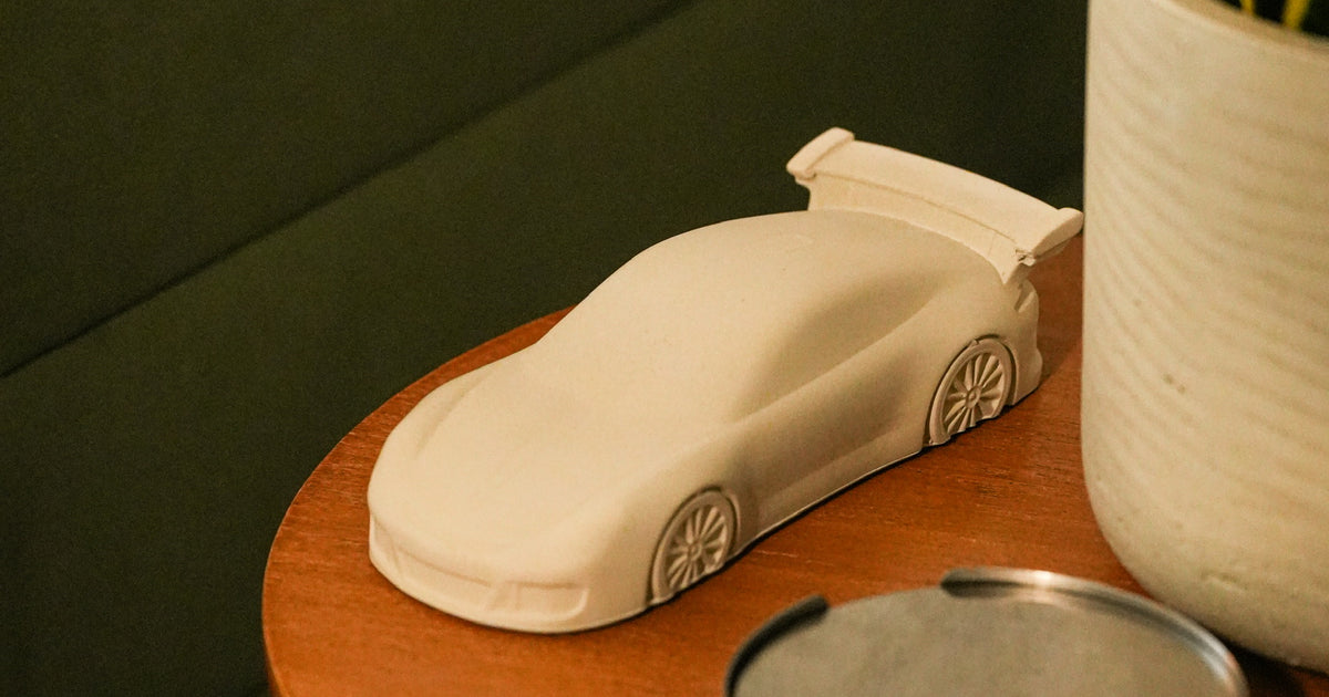 Concrete Porsche GT3 on a side table beside a green sofa